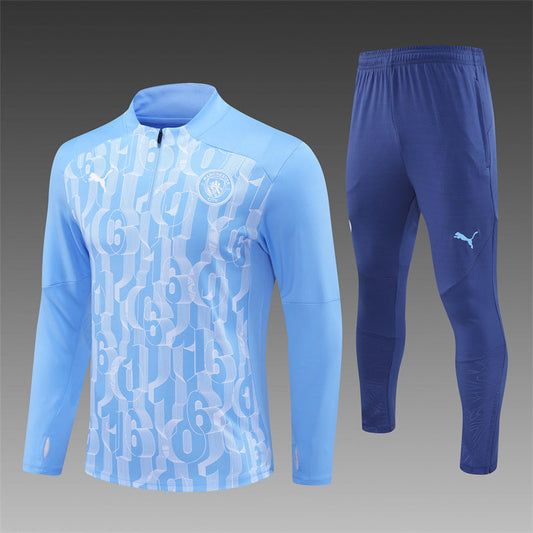 Manchester City 2024/2025 blue tracksuit laid flat with full zip jacket and pants.